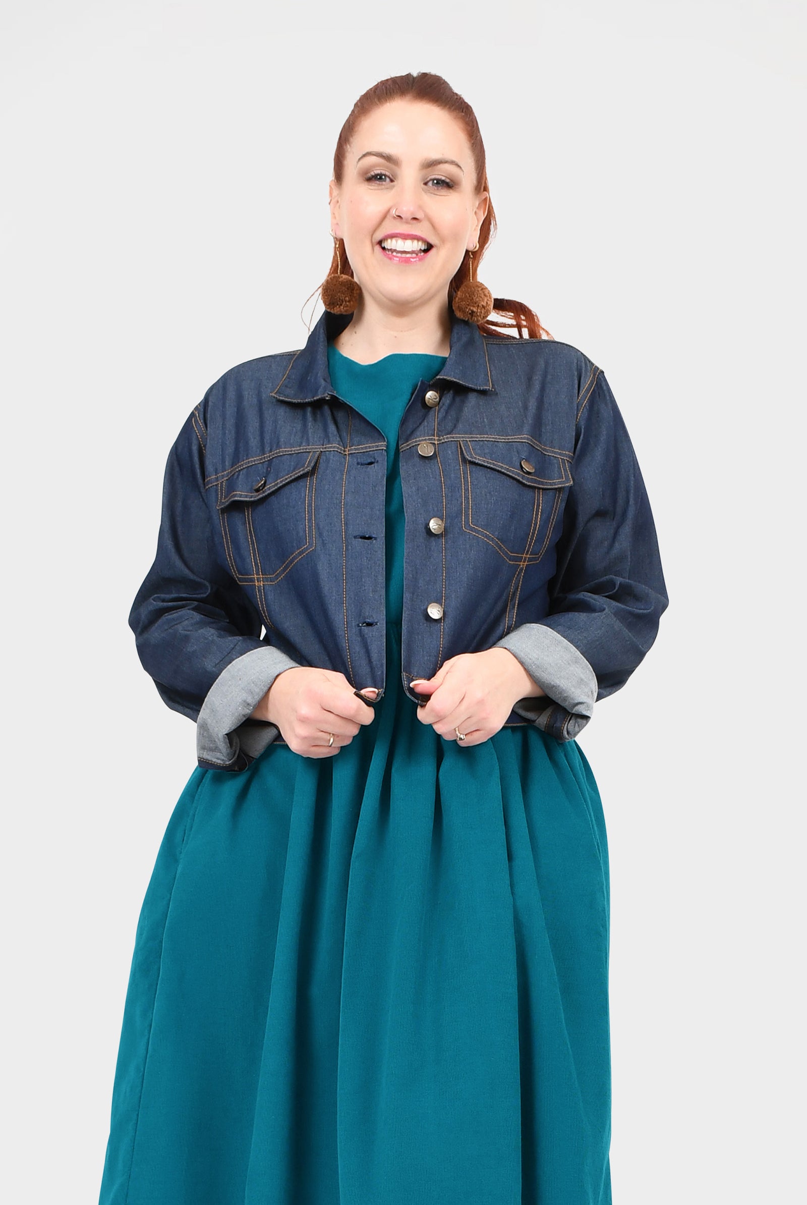 Dark blue denim jacket with button front, chest flap pockets, and stand collar