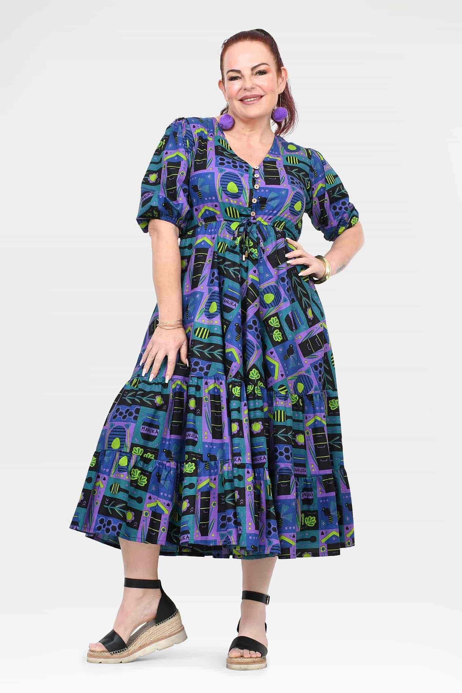 Ava midi dress on model, front view with V-neck and puff sleeves in teal-purple print