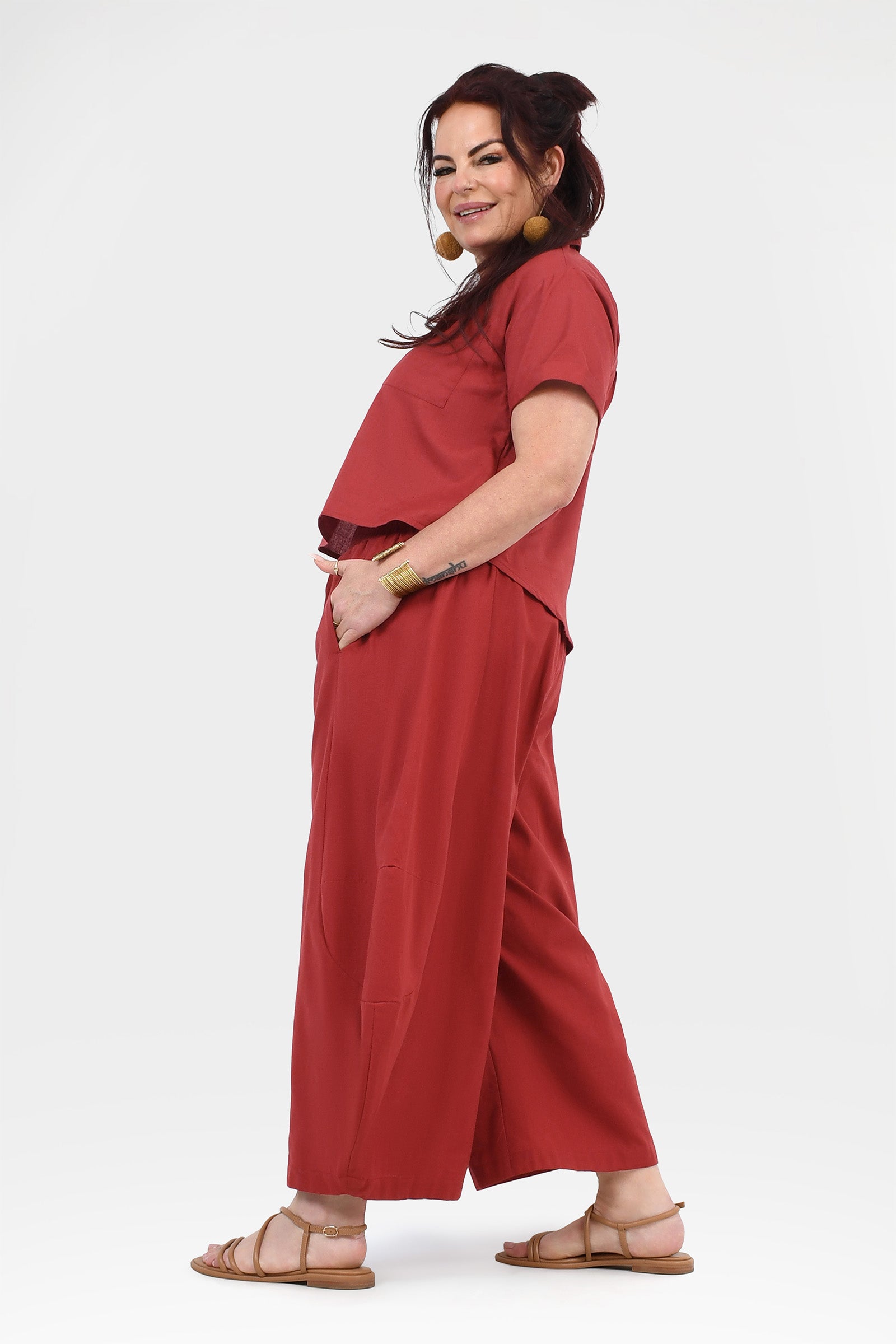 Side view of dark red wide-leg pants with elastic waistband and flowing legs.