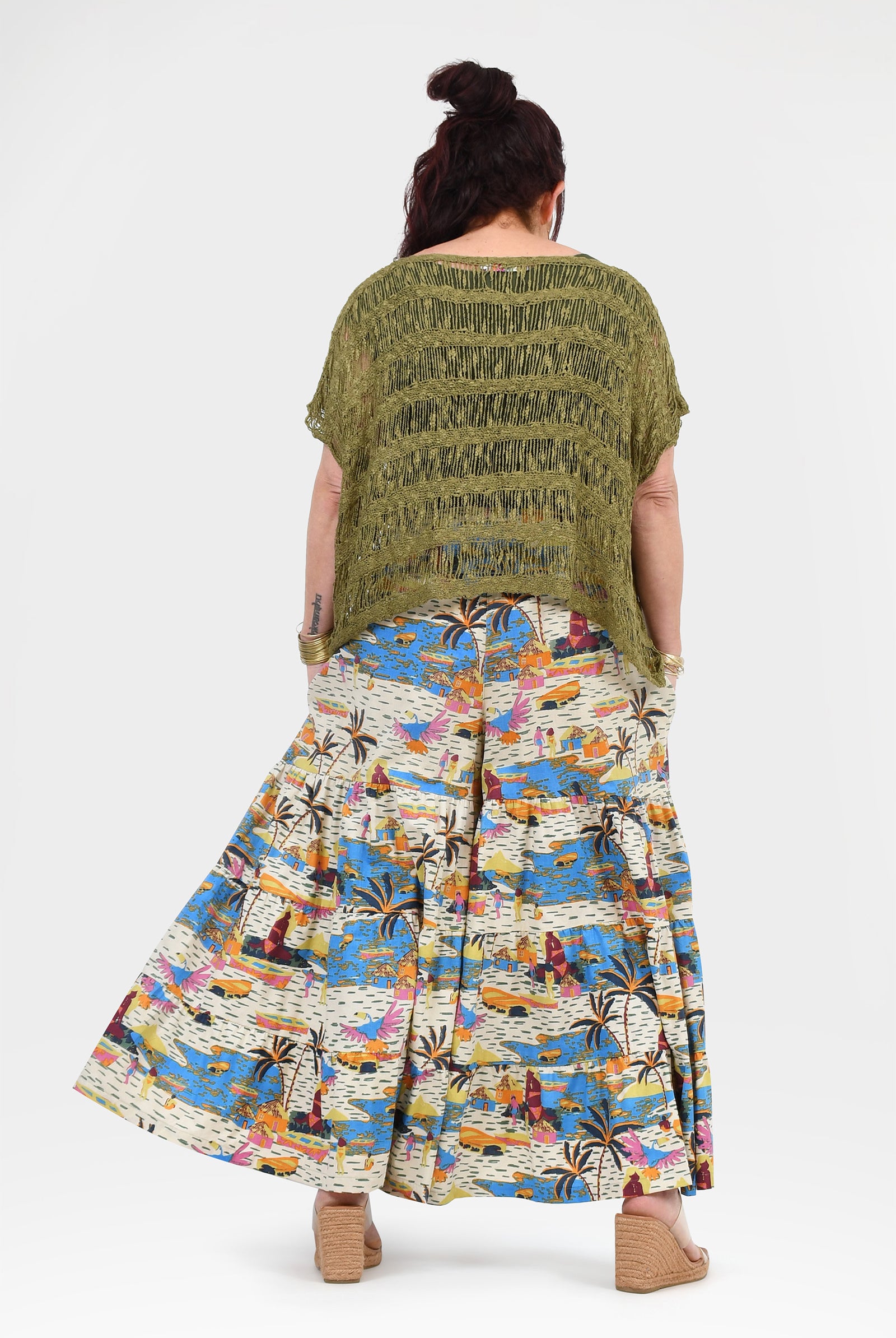 Back view of printed wide-leg pants; white with blue-orange tropical design and elastic waist