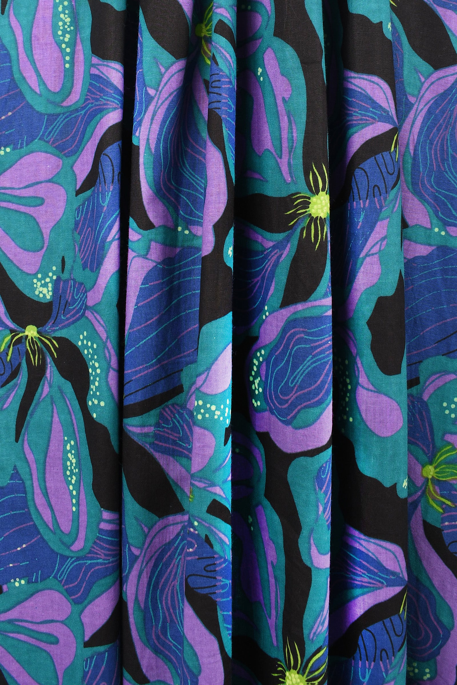 Close-up of reversible skirt fabric, teal and purple abstract pattern with neon accents