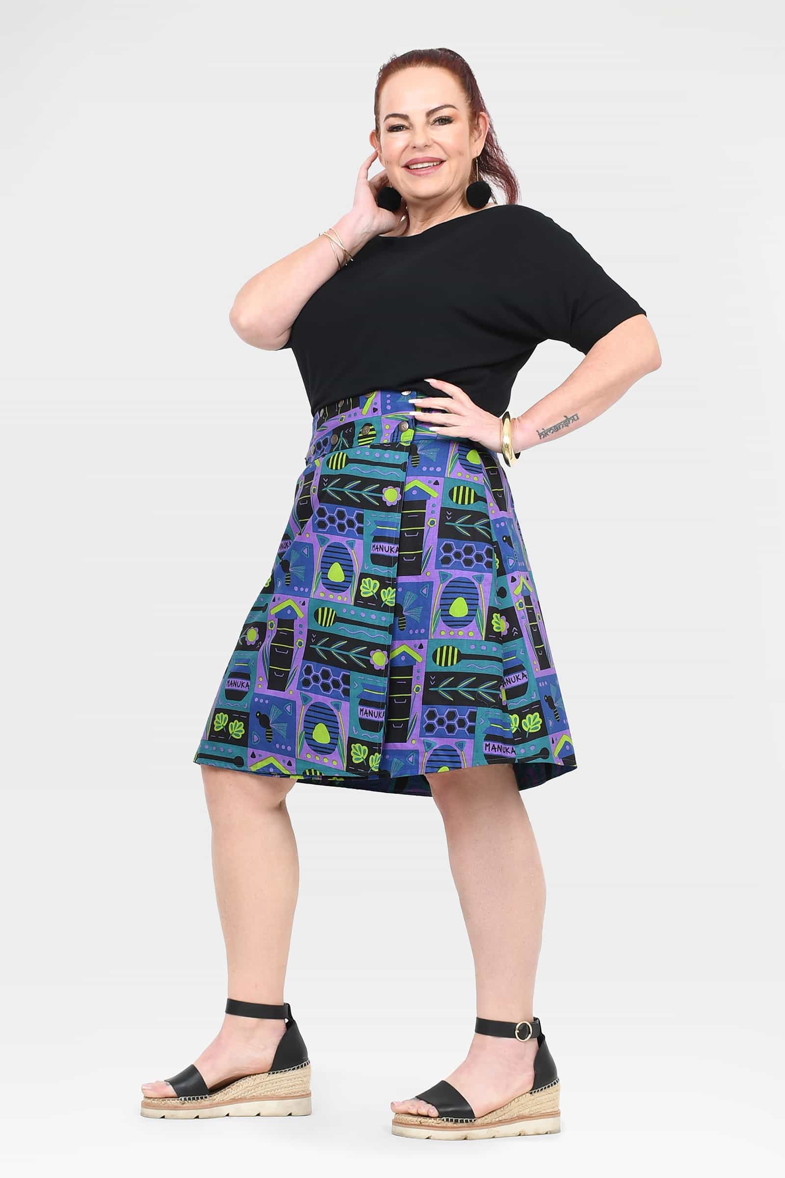 Reversible button skirt with black yoke and teal, purple, and green geometric print