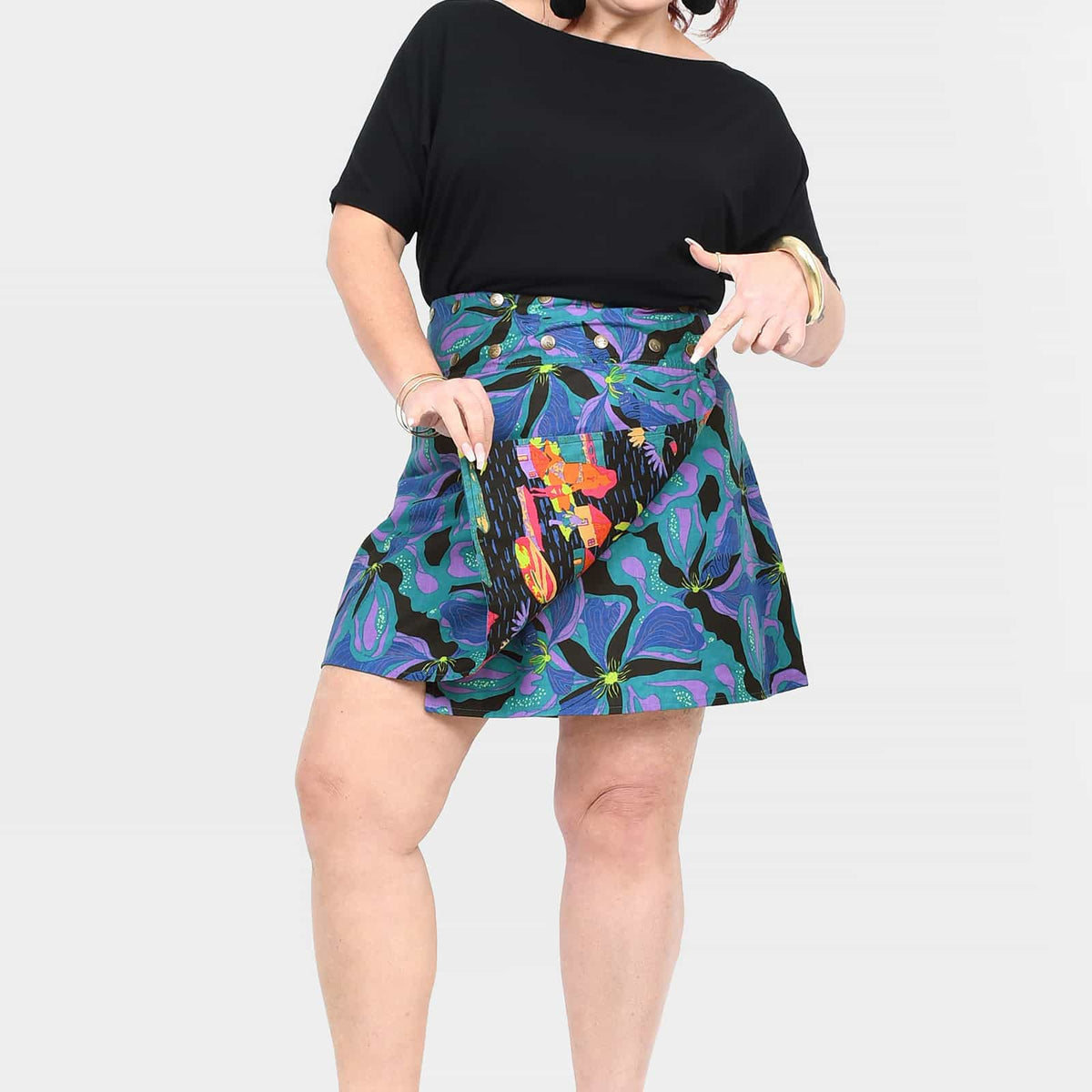 Reversible short button skirt, teal floral print with orange accents and black reverse