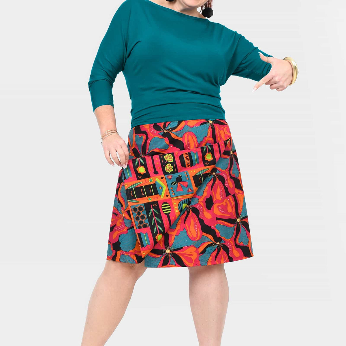Long reversible skirt with button front; teal side and colorful tropical print side