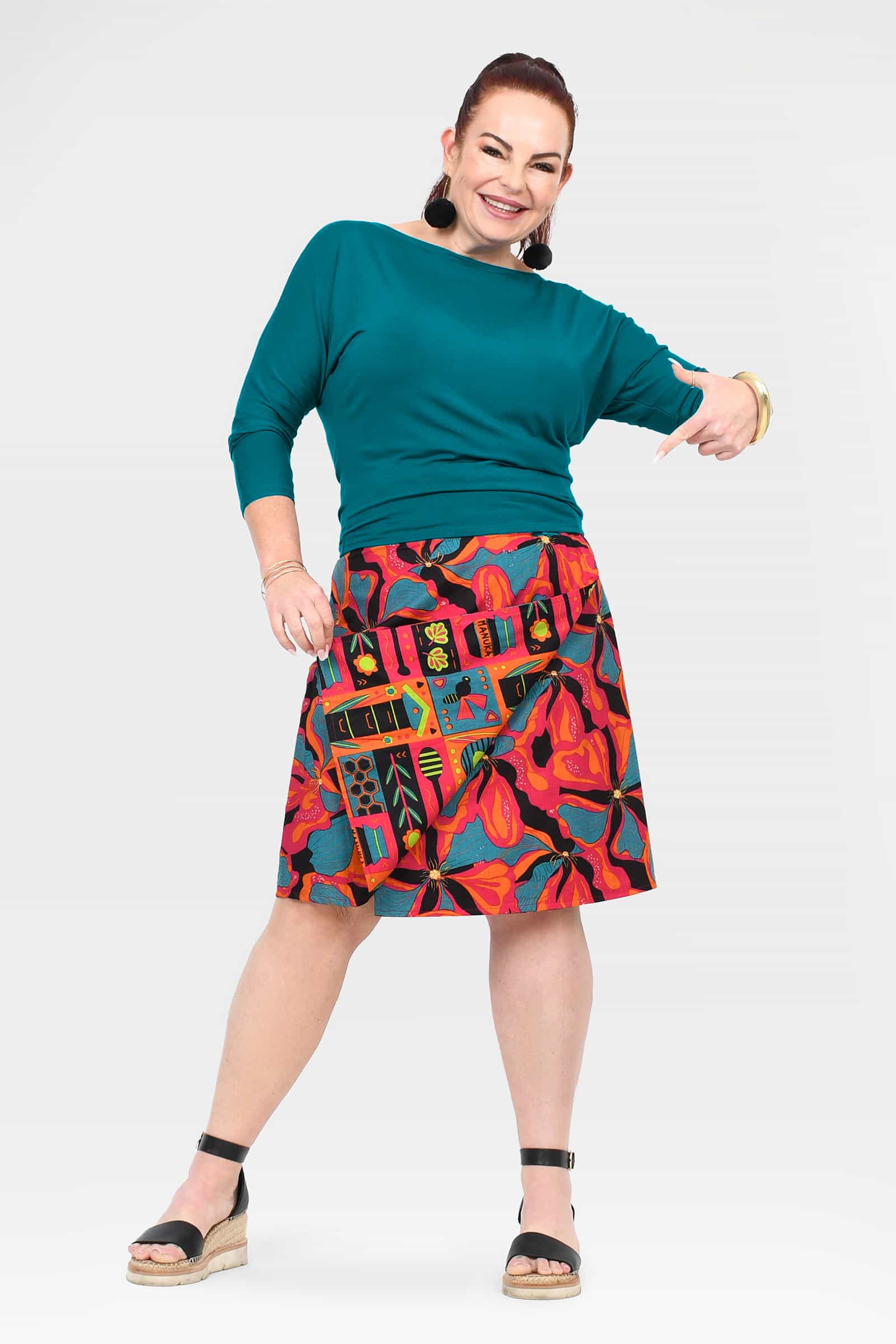 Long reversible skirt with button front; teal side and colorful tropical print side