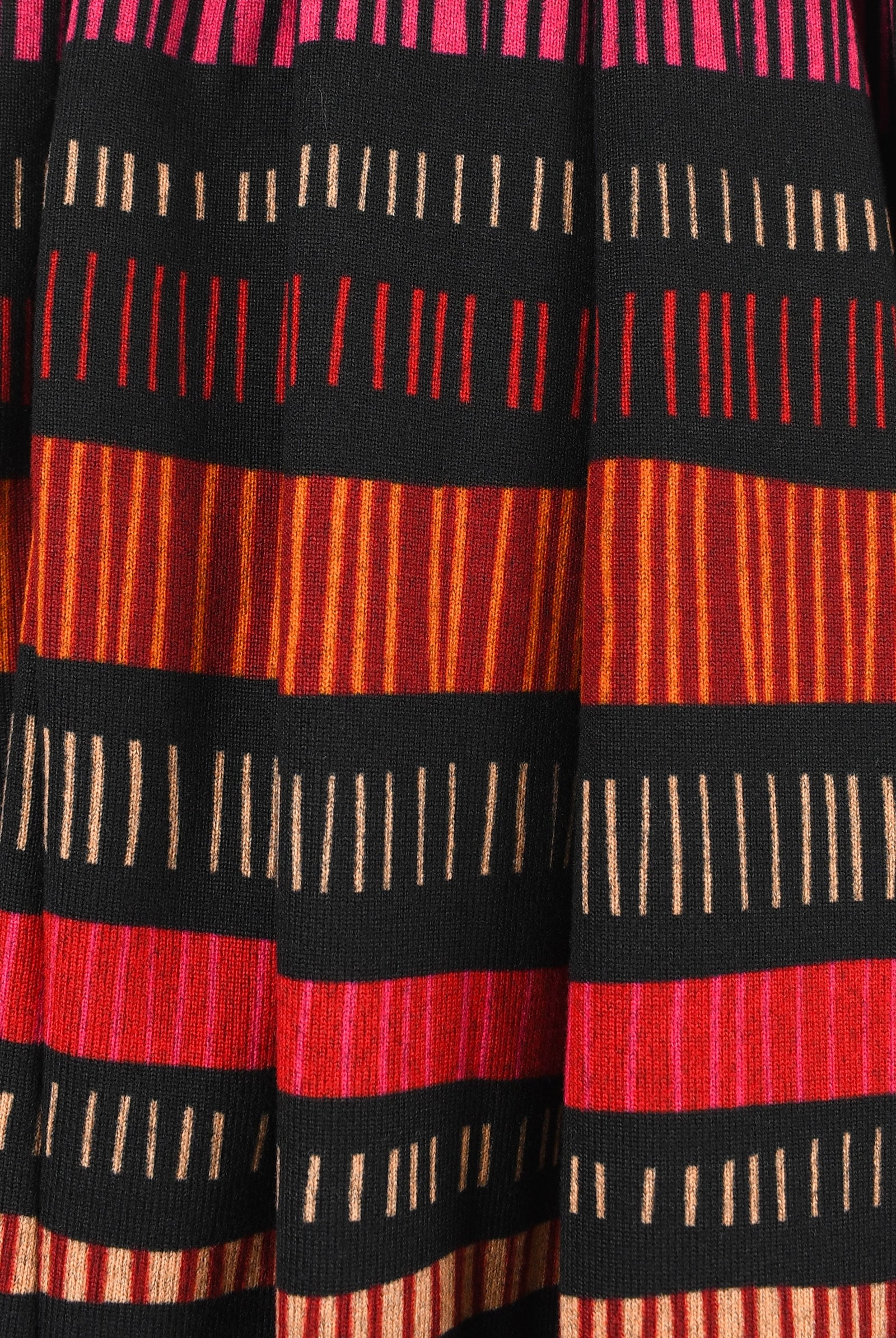 Close-up of a fabric with red, black, and orange striped pattern