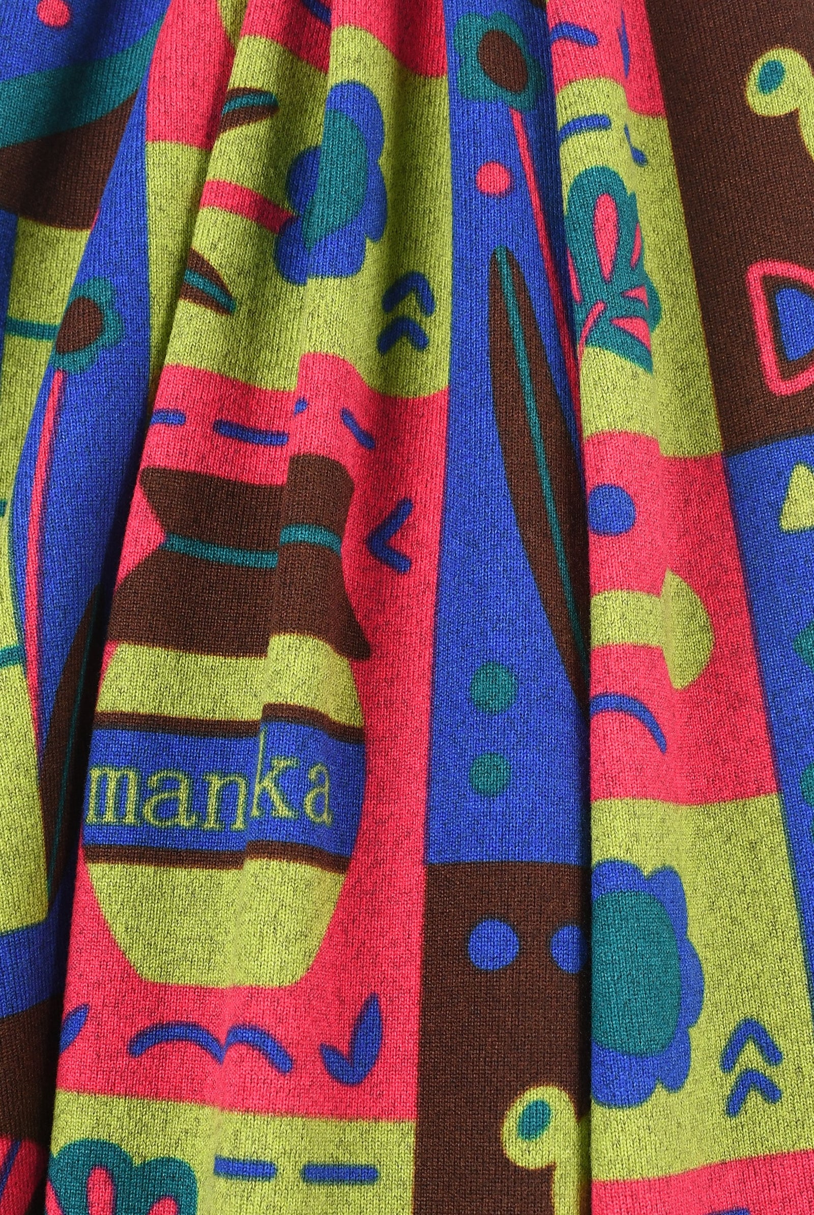 Colorful fabric with abstract patterns and 'manka' branding.