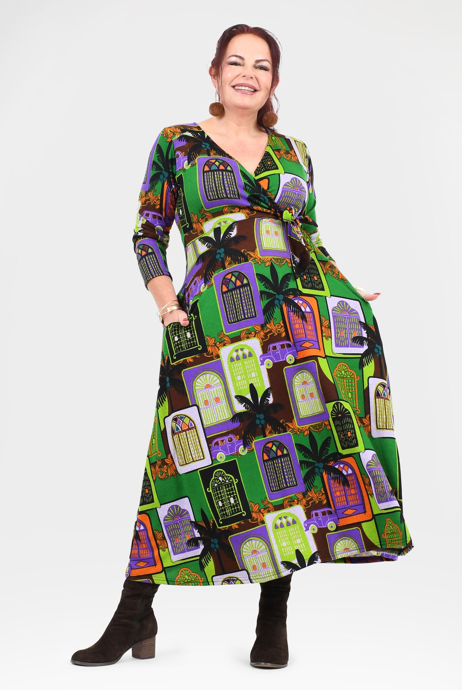 Woman wearing a colorful dress with a pattern of haunted houses on a white background