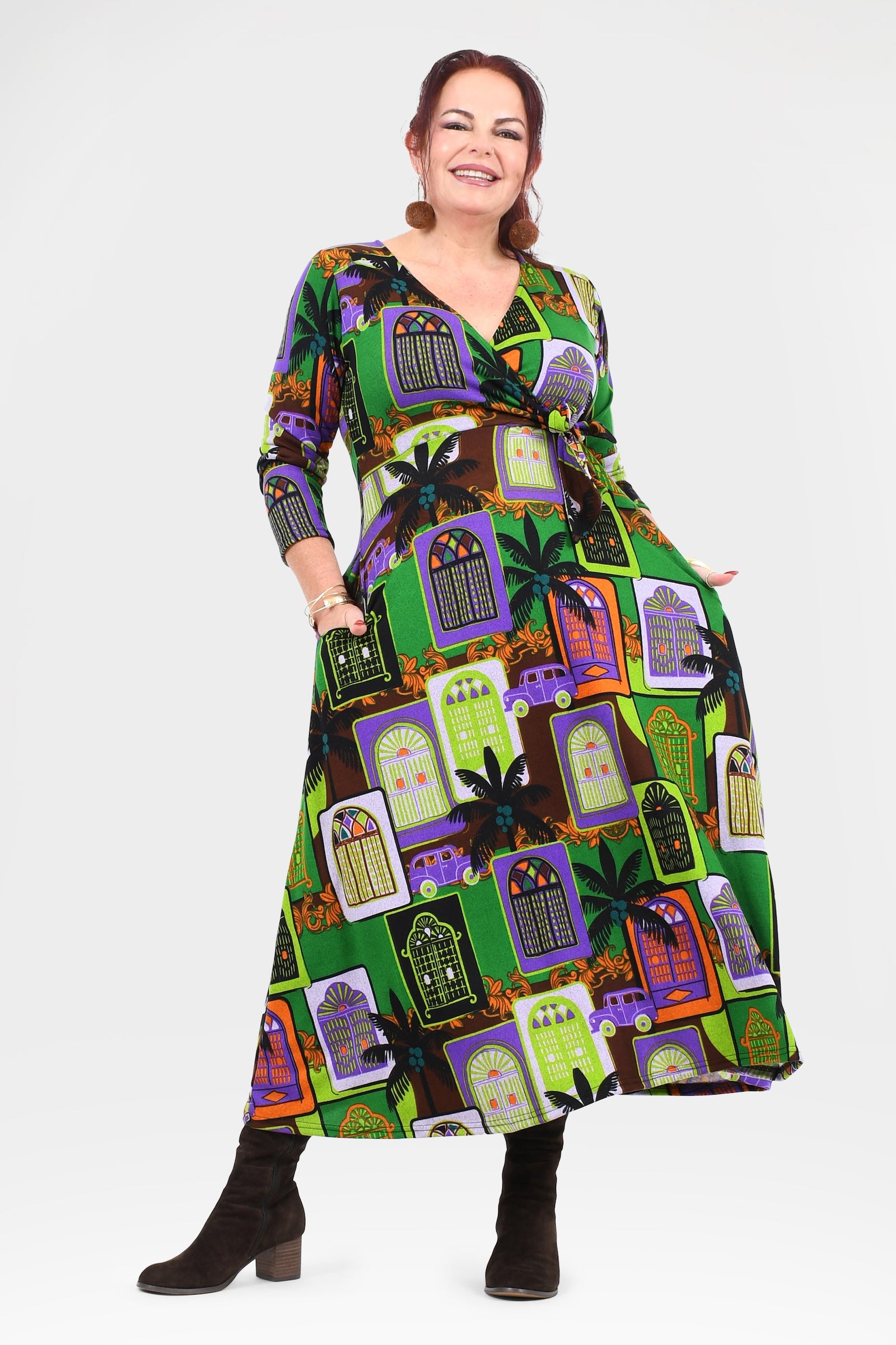 Woman wearing a colorful dress with a pattern of haunted houses on a white background