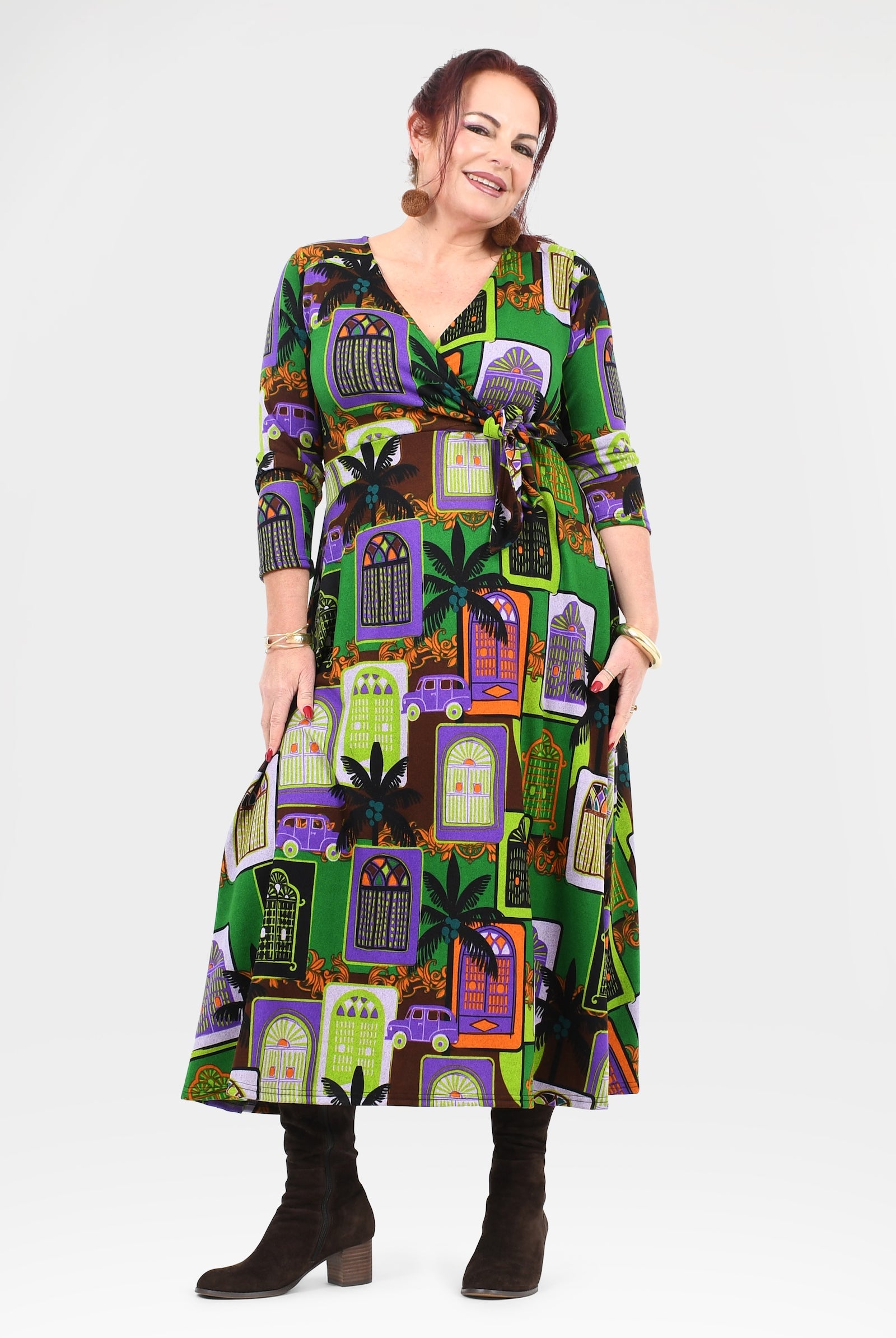 Woman wearing a colorful dress with haunted house pattern on a white background