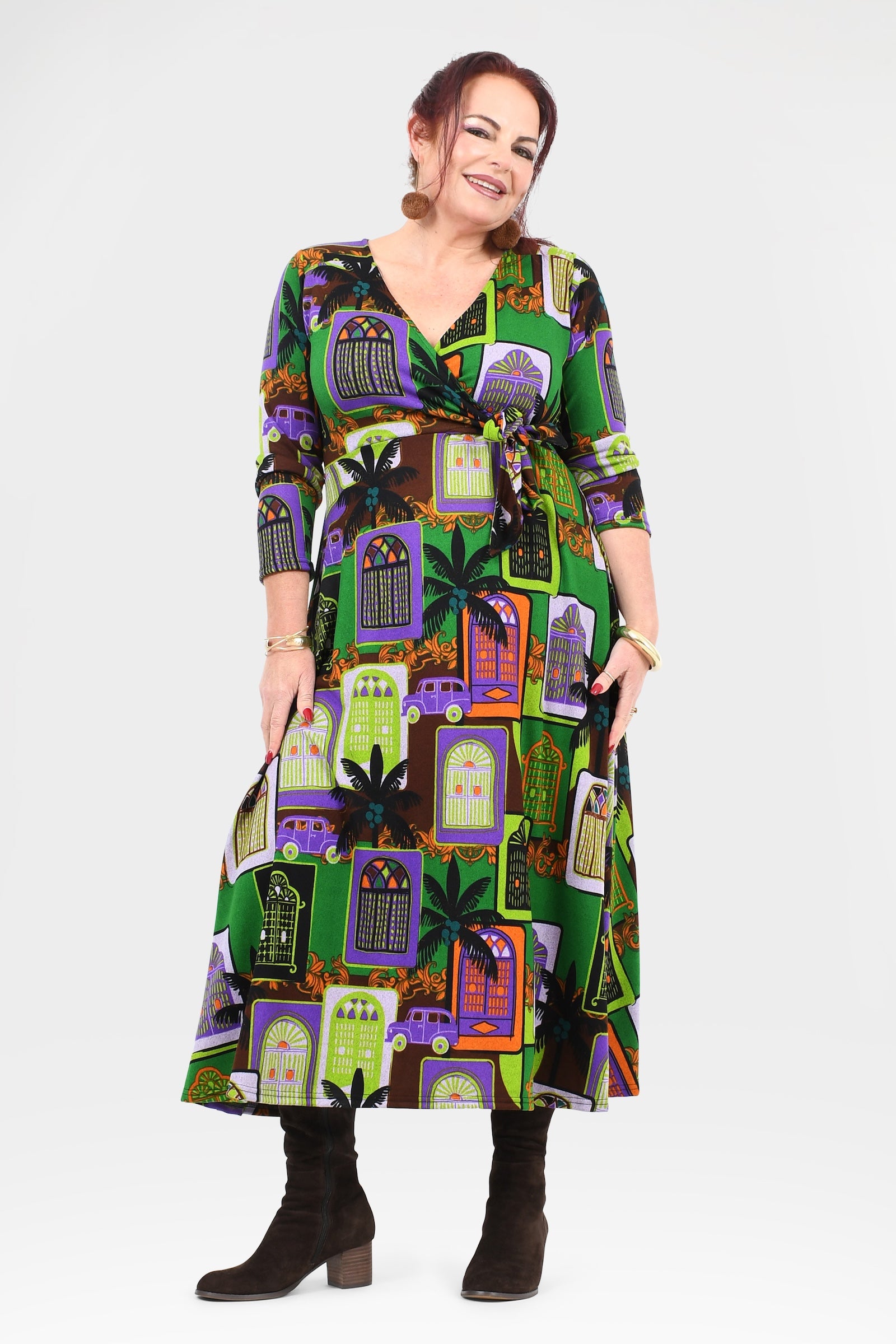 Woman wearing a colorful dress with haunted house pattern on a white background
