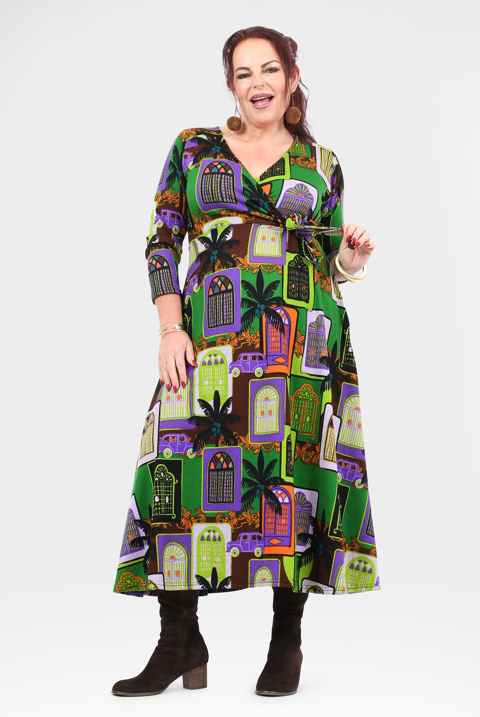 Woman wearing a colorful dress with a pattern of haunted houses on a white background