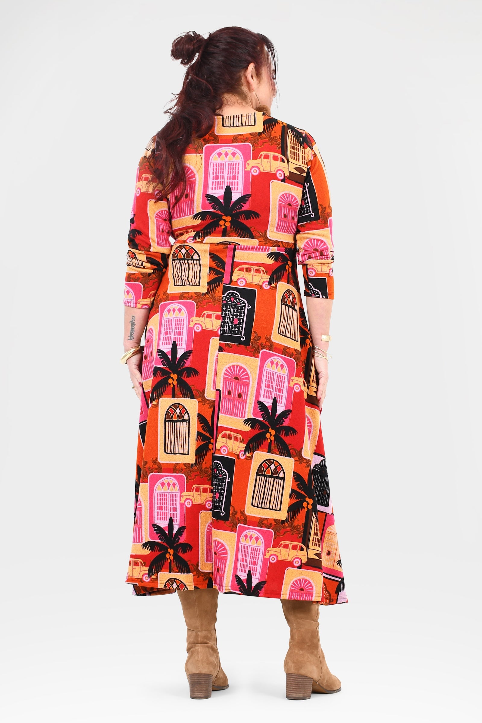 Person wearing a colorful patterned dress on a white background