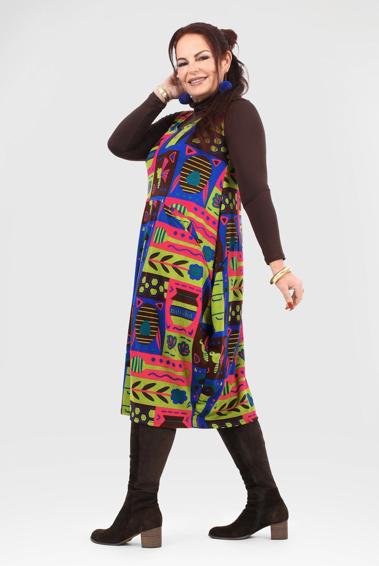 Woman wearing a colorful patterned dress on a white background