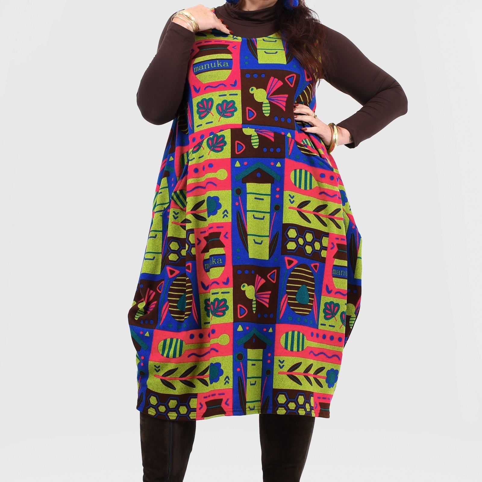 Woman wearing a colorful patterned dress with a plain background