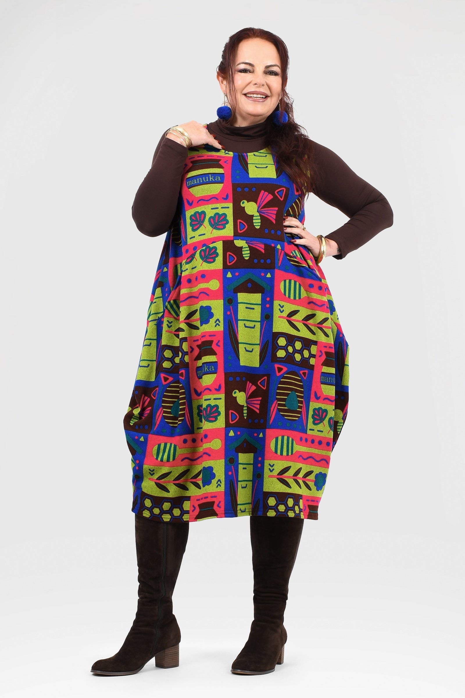 Woman wearing a colorful patterned dress with a plain background