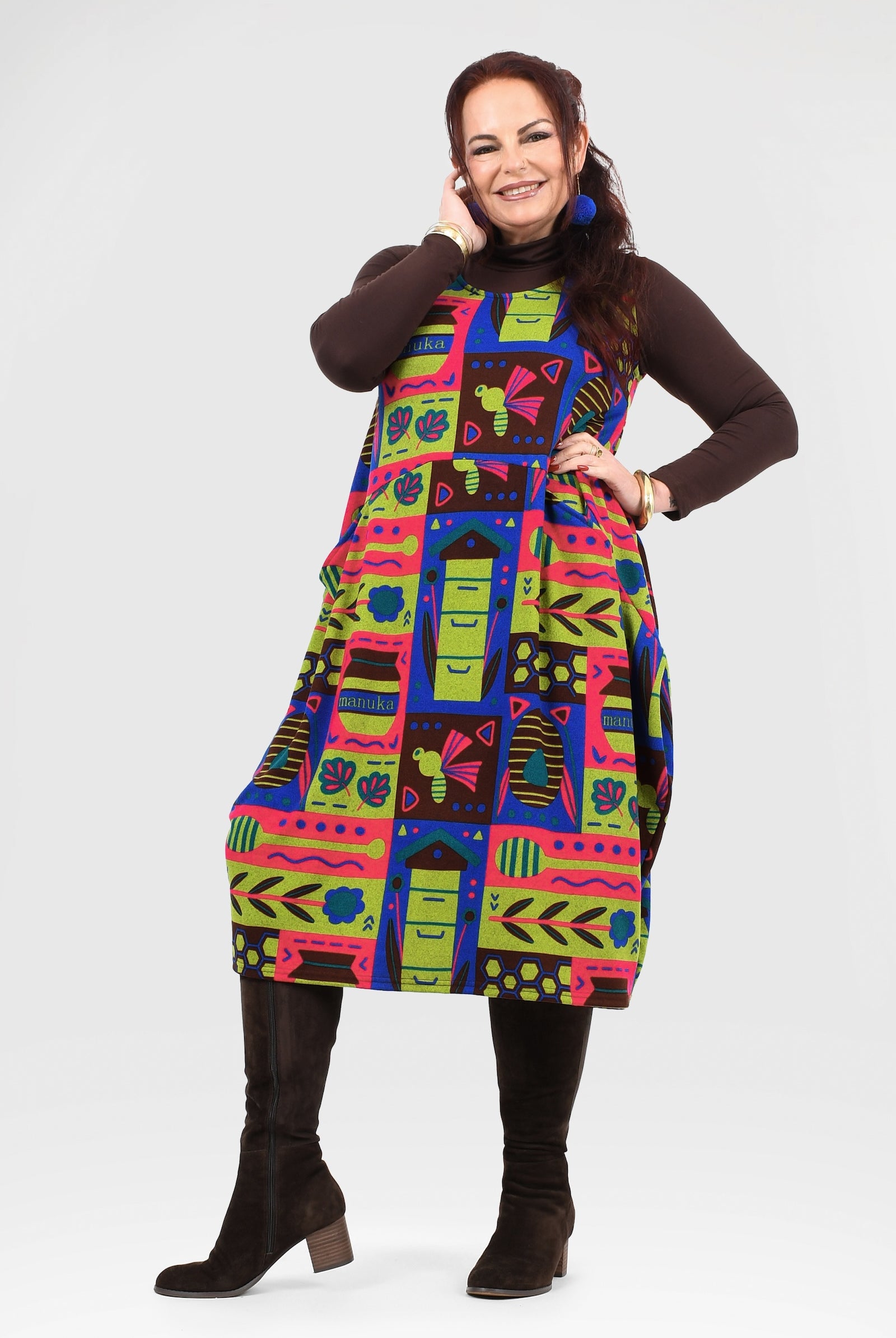Woman wearing a colorful patterned dress with a white background