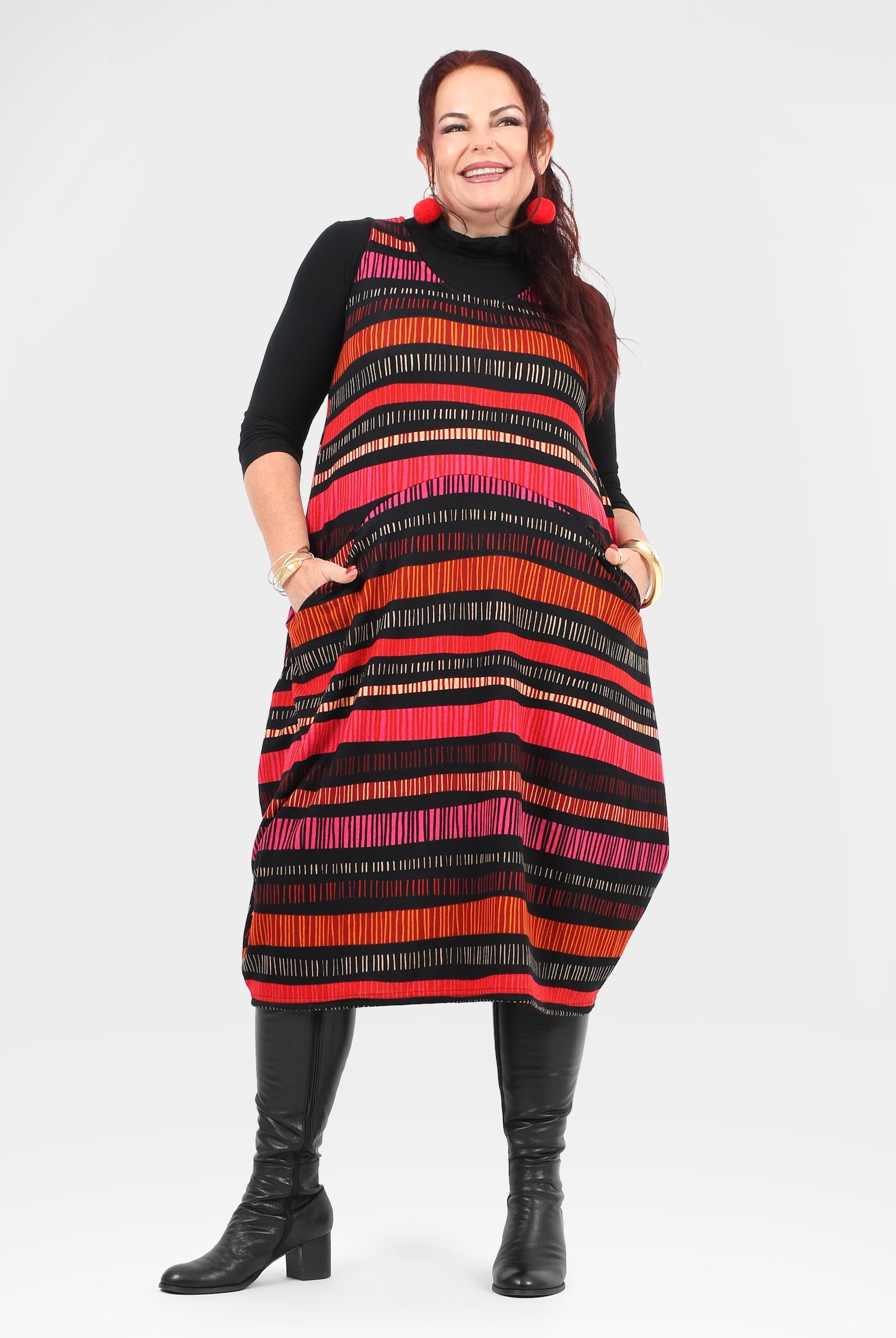 Woman wearing a black, red, and orange striped dress on a white background