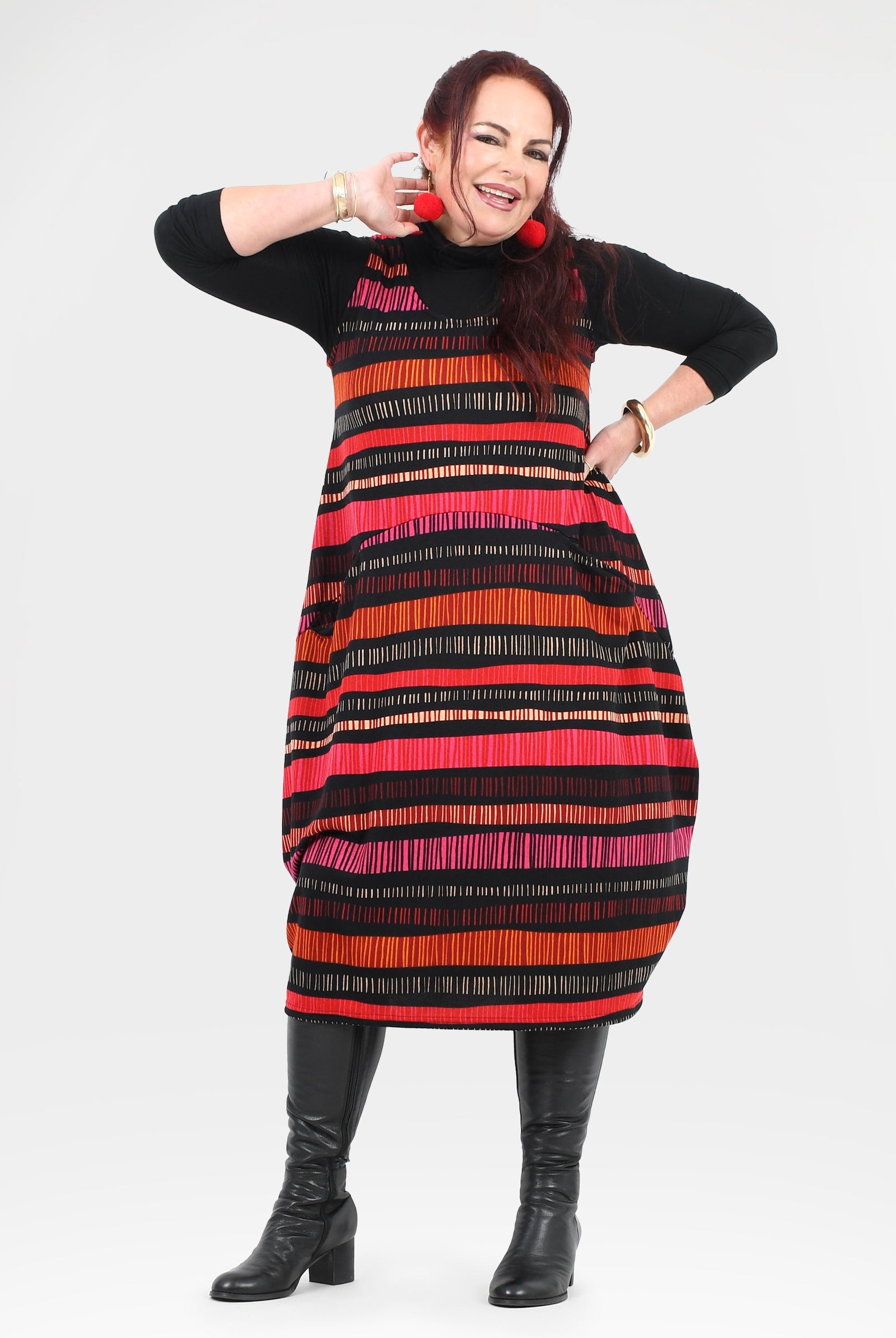 Woman wearing a black dress with a colorful striped pattern on a white background
