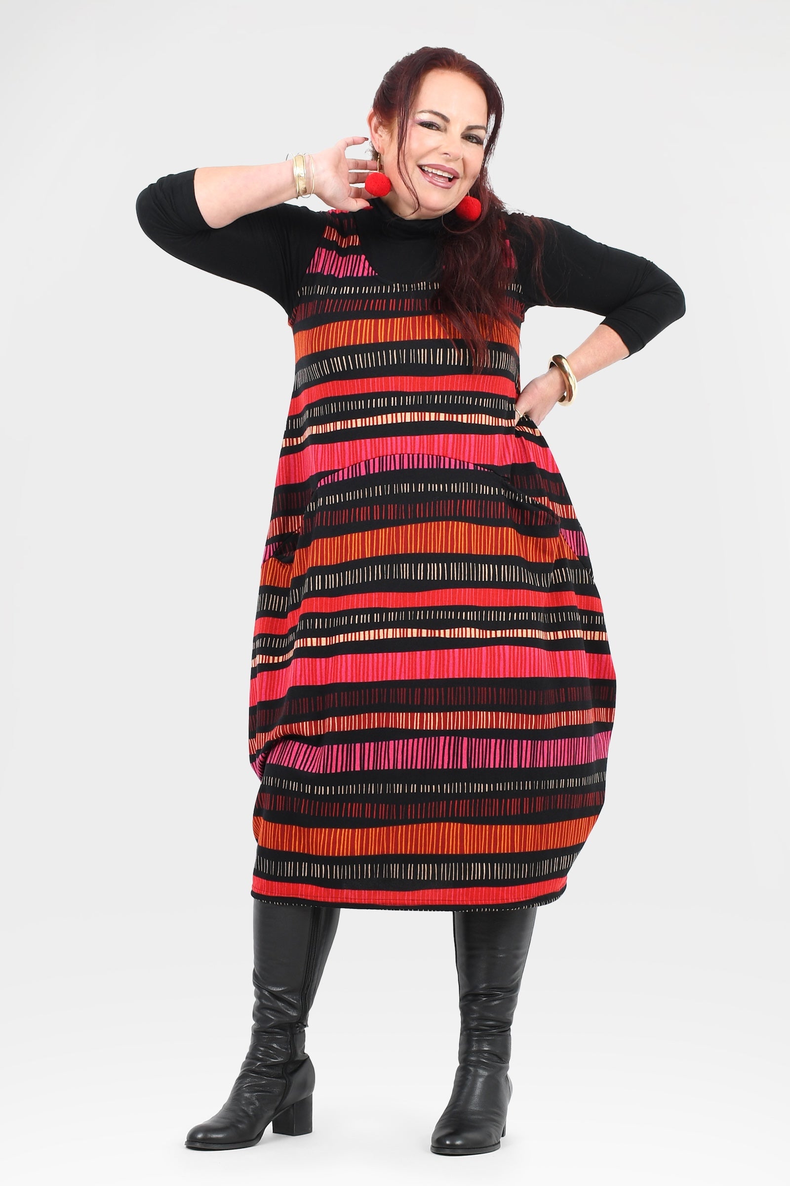 Woman wearing a black dress with a colorful striped pattern on a white background