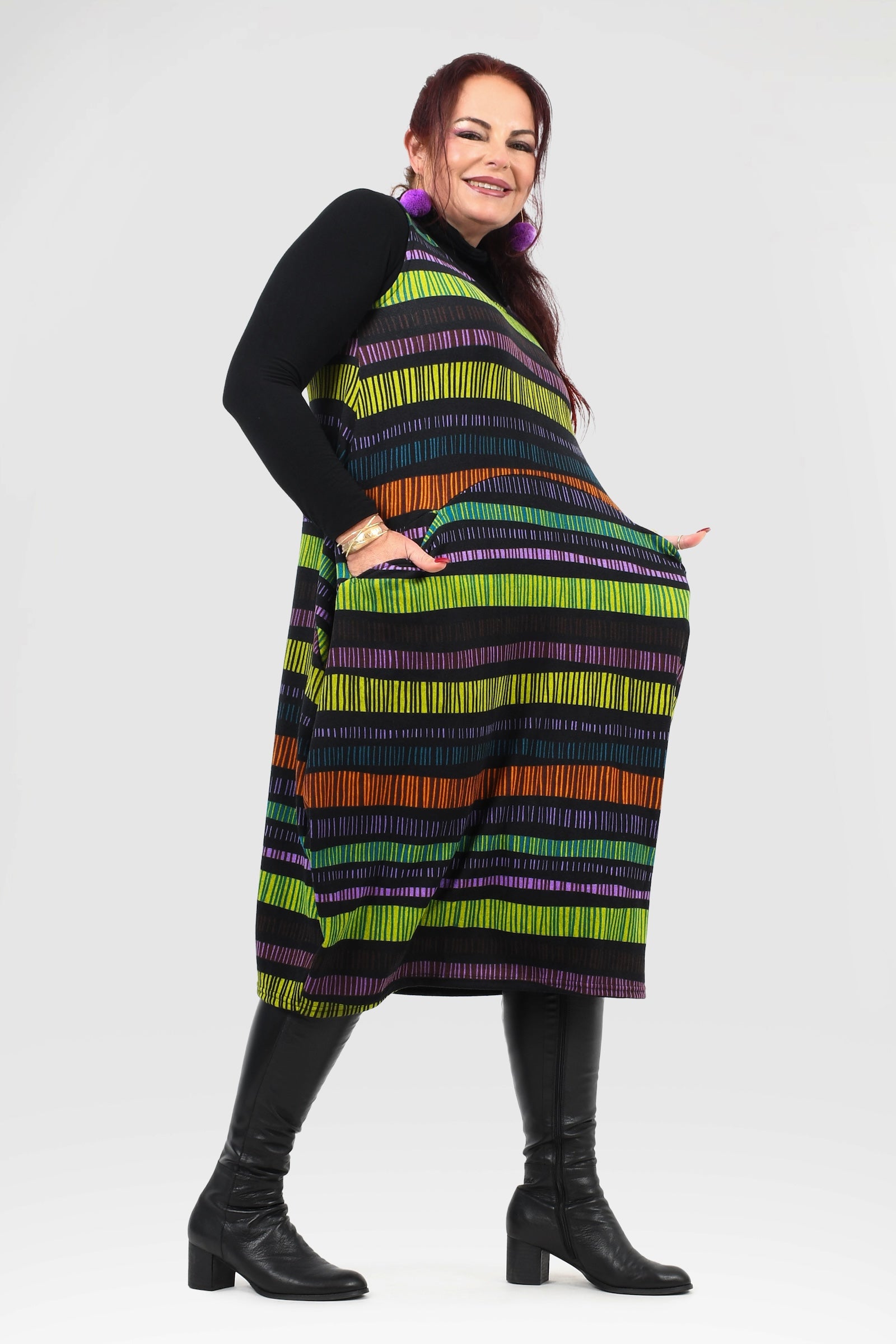 Woman wearing a colorful striped dress with a black top on a white background