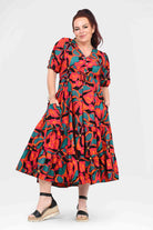 Tiered midi dress in vibrant coral and teal floral print, short puff sleeves, A-line skirt