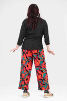 Wide-leg printed pants, abstract red and teal pattern, back view