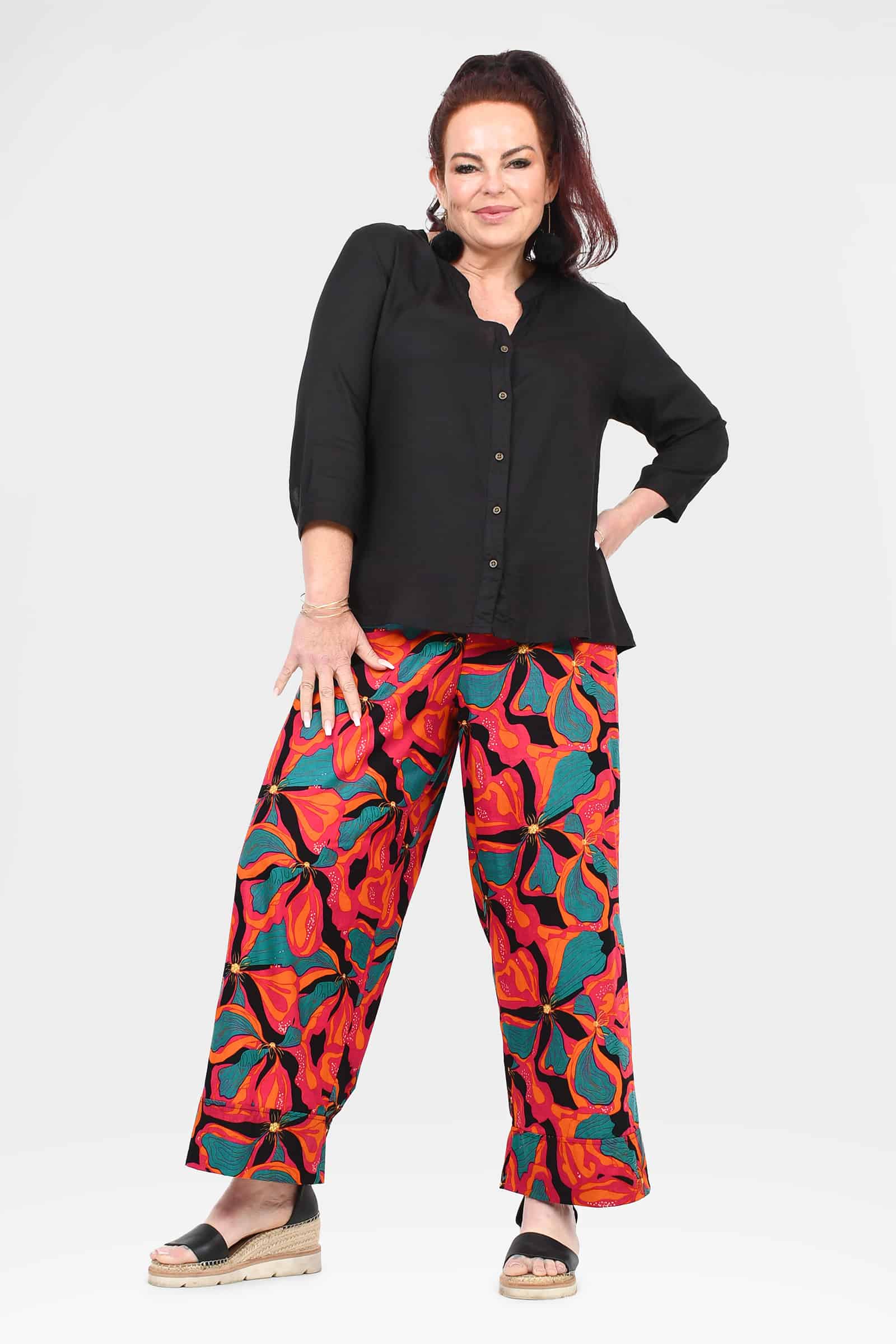Wide-leg printed pants with bold red, orange, and teal floral shapes