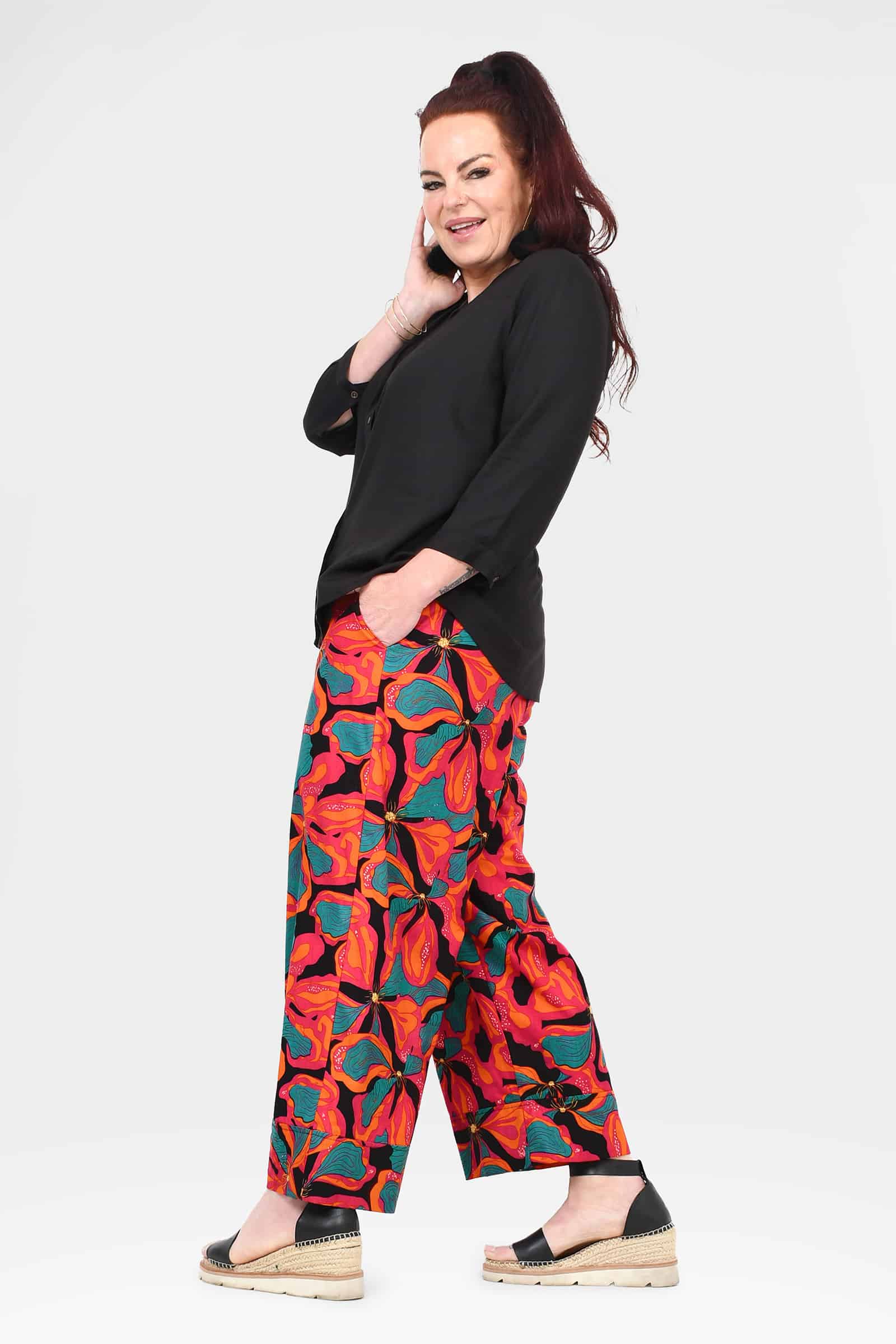 Wide-leg printed pants with abstract red and teal leaf-like design