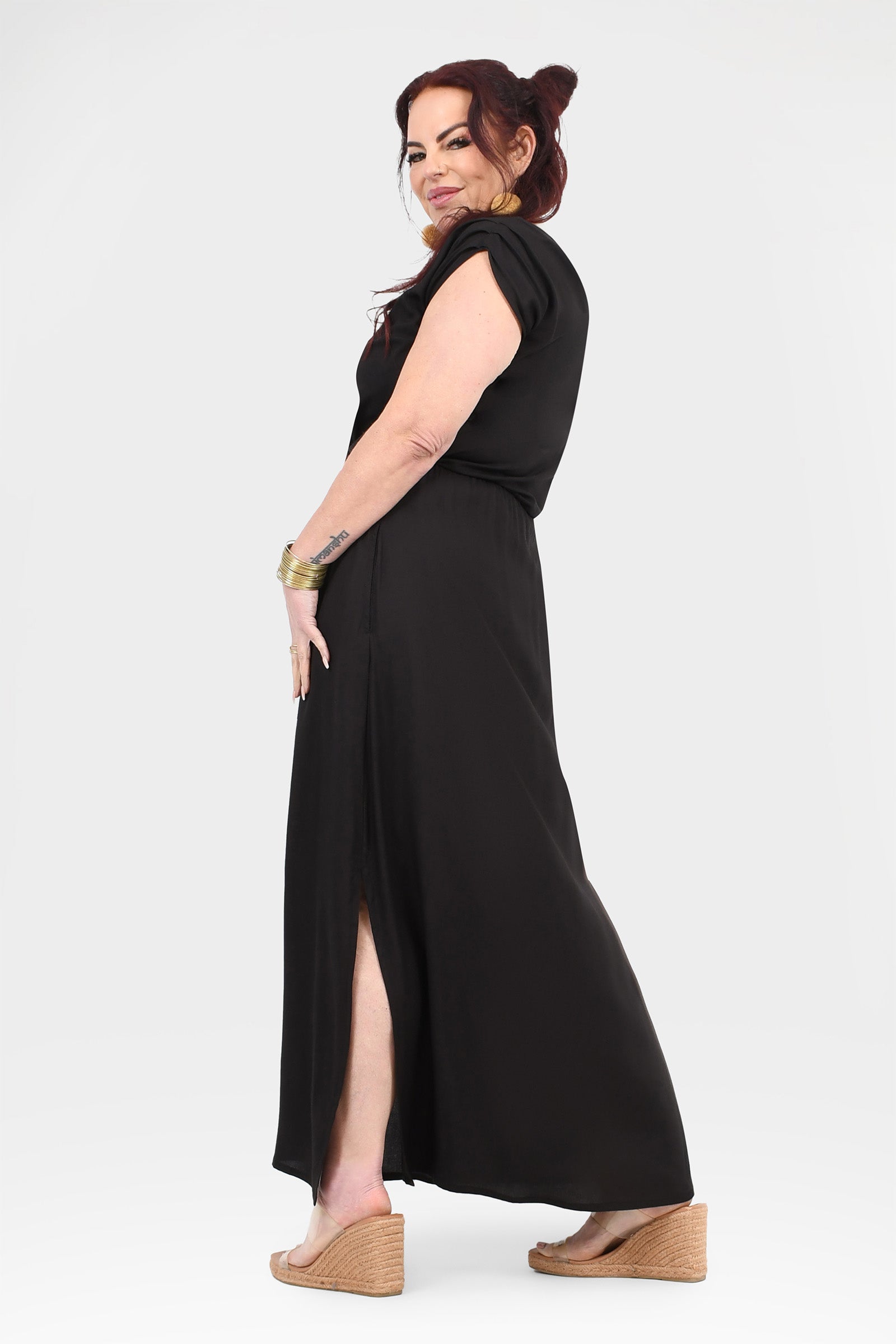 Black maxi dress side view with short sleeves, cowl neckline, and thigh-high slit
