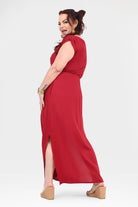 Dark red maxi dress, cap sleeves, gathered waist, and side slit; side view