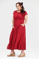 Dark red long dress with round neckline, gathered waist and pleated flowy skirt