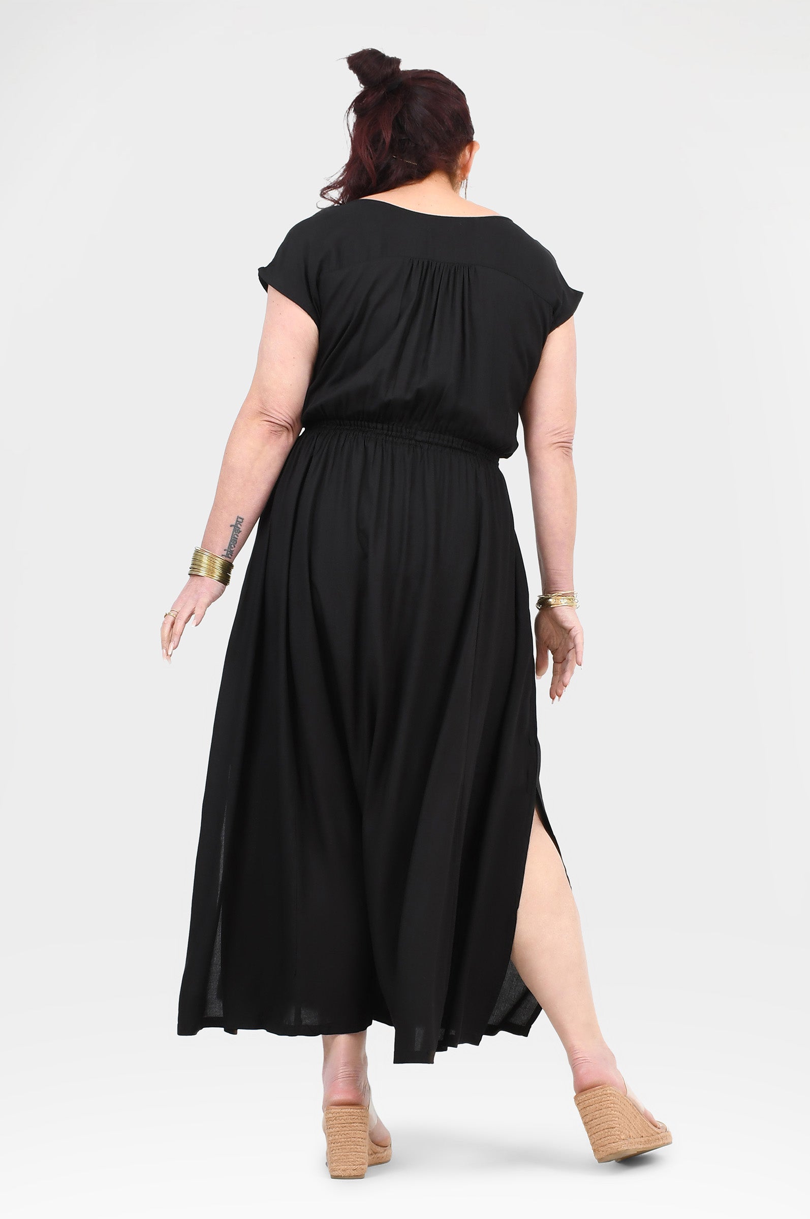 Black long dress from behind with short sleeves, gathered waist, and side slit