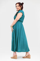 Teal long dress with short cap sleeves, side view, gathered waist and pleated skirt