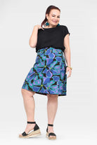 Side view of tropical print skirt on dark base with flared A-line hem