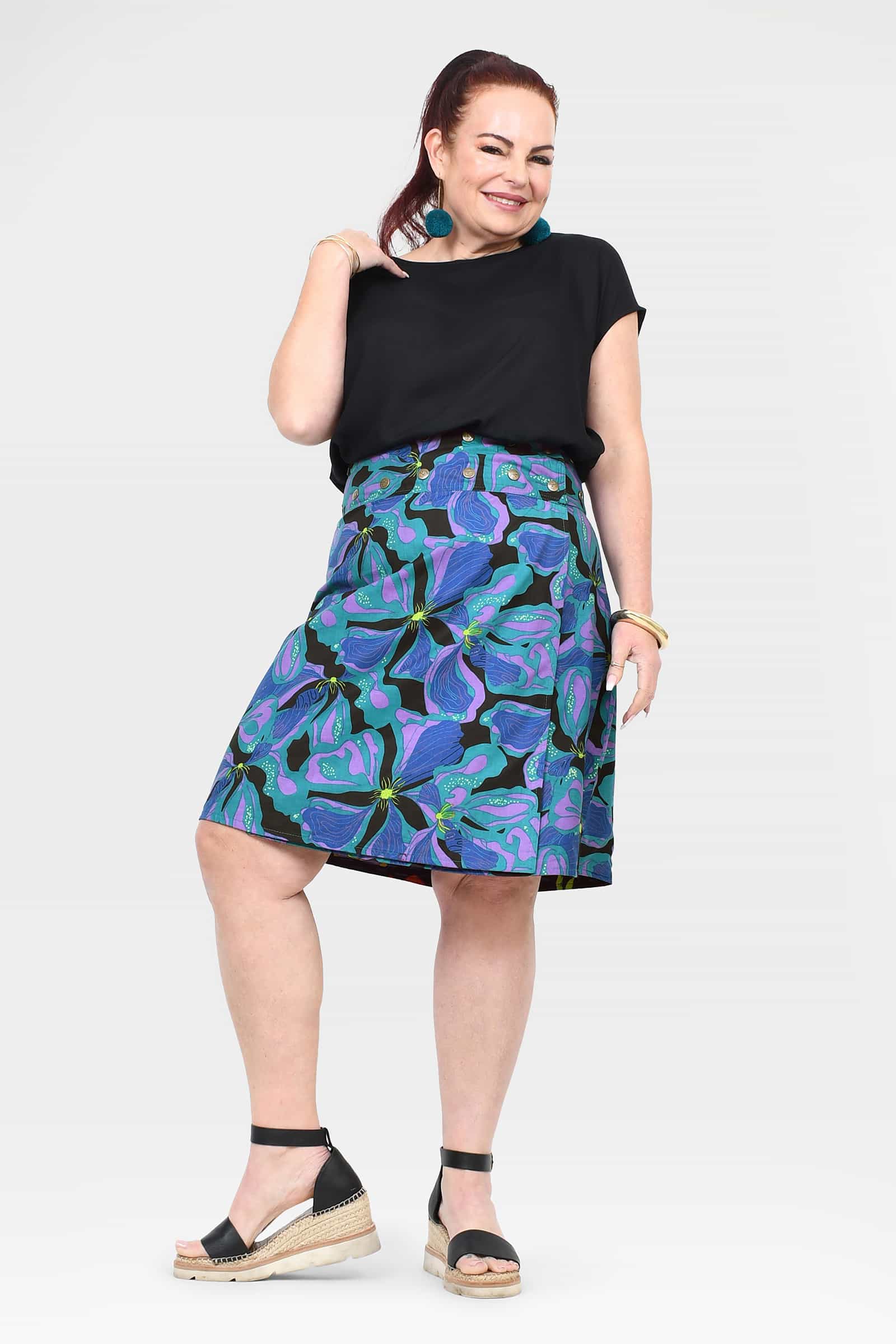 Side view of tropical print skirt on dark base with flared A-line hem