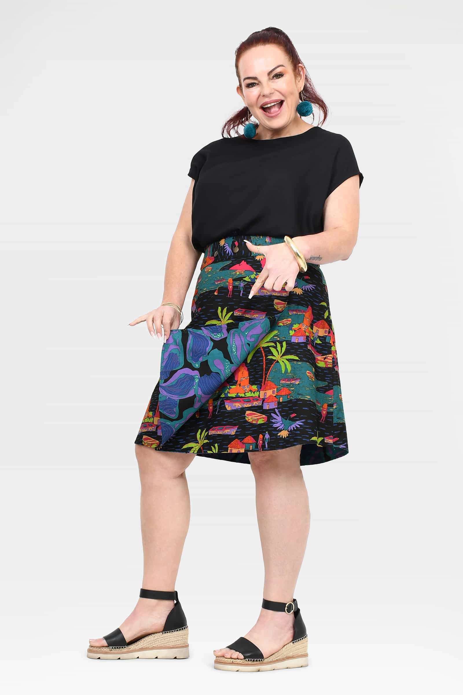 Front view of tropical print skirt with colorful houses and palm trees