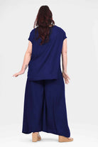 Dark navy wide-leg pants, back view, draped ankle-length trousers