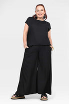 Black wide-leg pants with elastic waistband and relaxed full-length drape