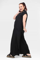 Black wide-leg pants with side view; elastic waist and flowing wide-leg silhouette