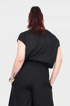 Black short-sleeve top with crew neckline, back view, relaxed drape.