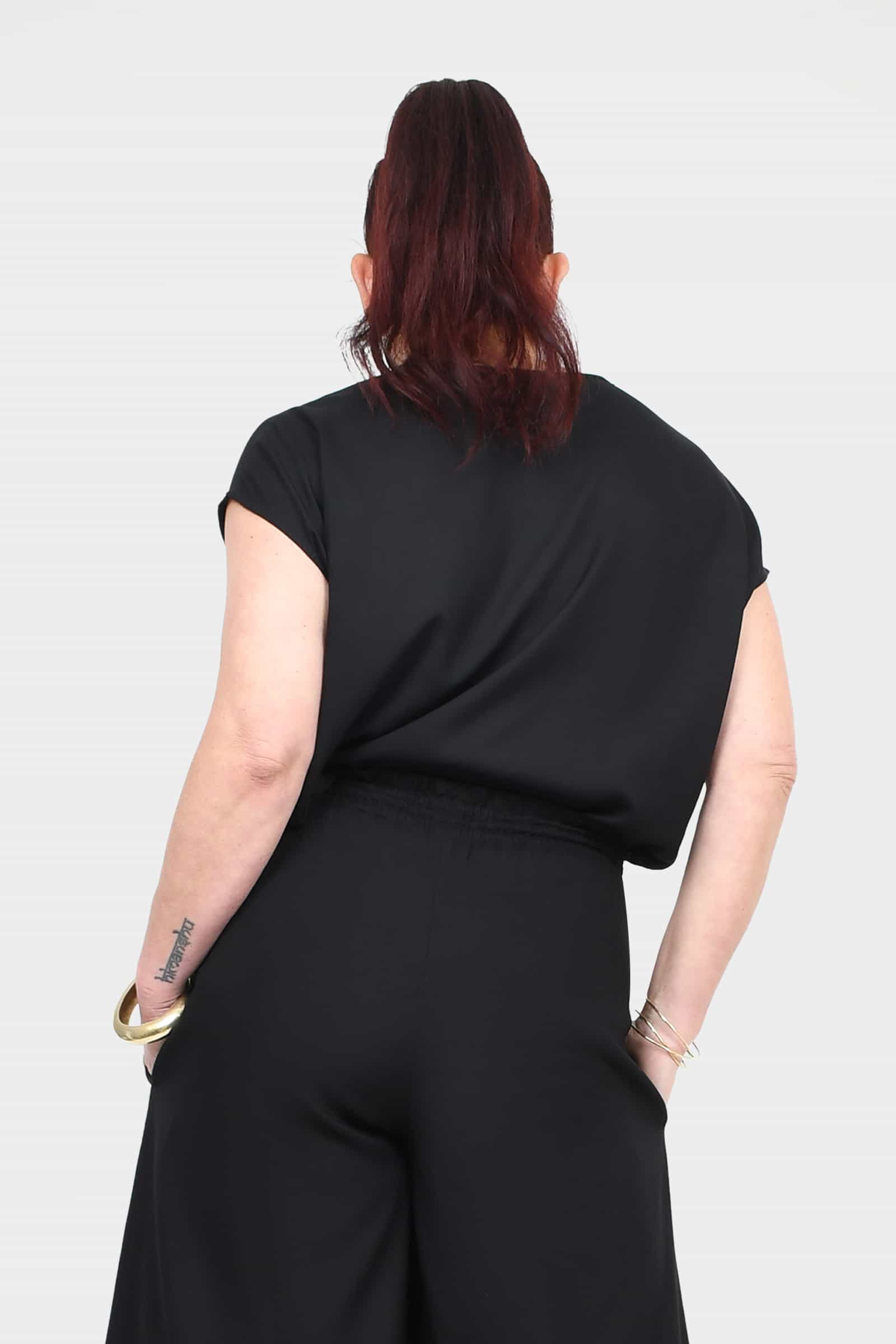Black short-sleeve top with crew neckline, back view, relaxed drape.