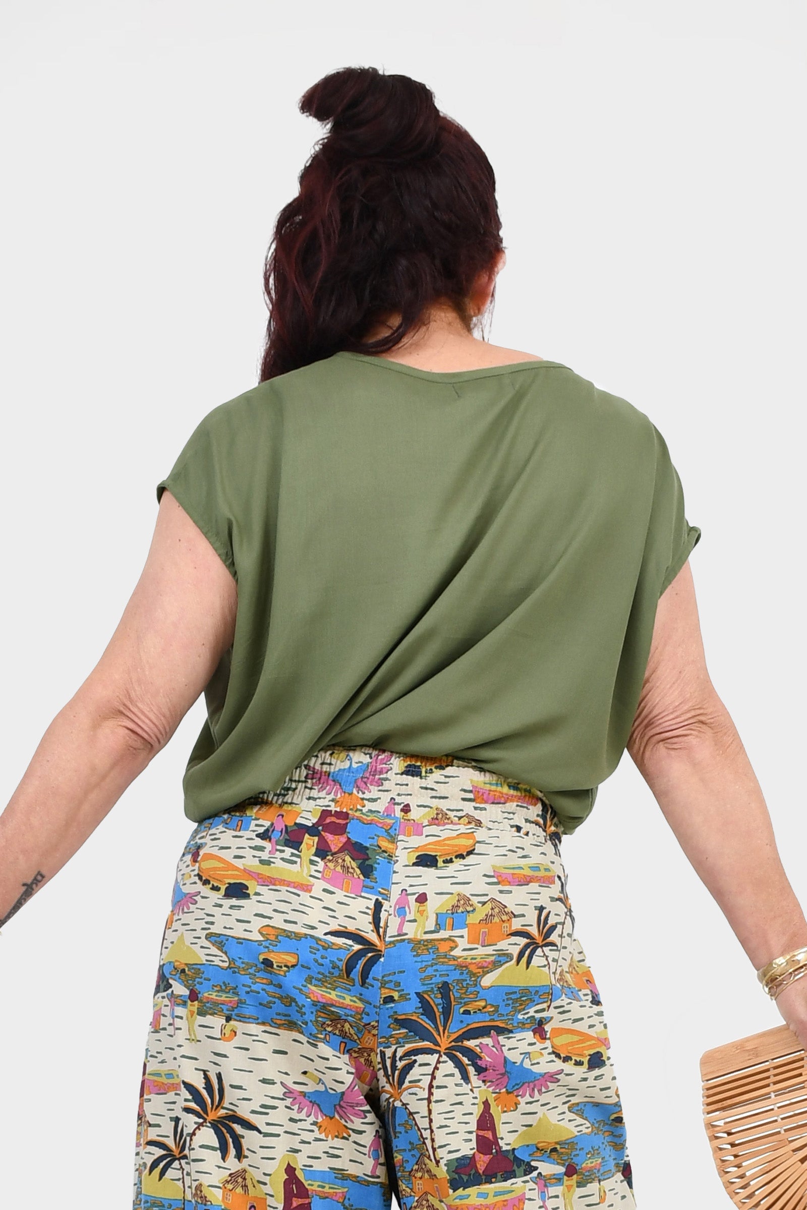 Back view of pistachio green Nora top with short sleeves and flowing shape