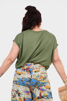 Back view of pistachio green Nora top with short sleeves and flowing shape