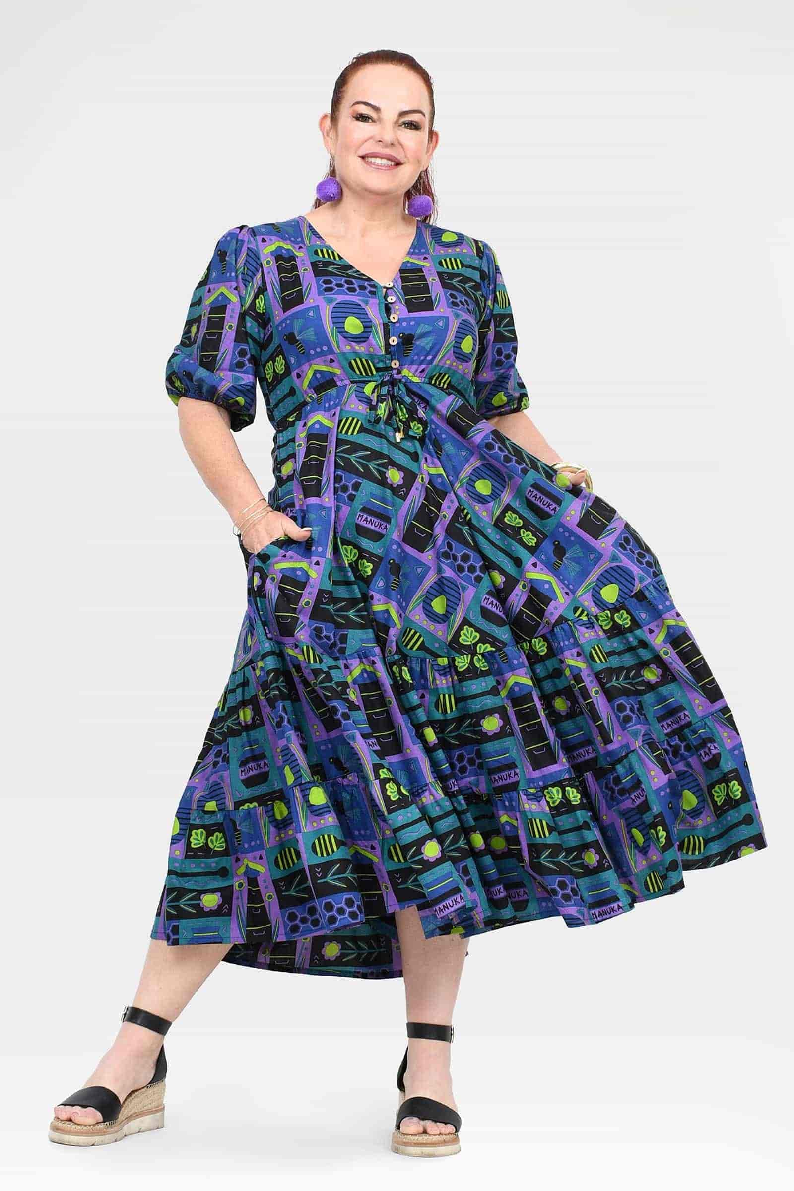 Ava midi dress on model, teal and purple geometric print with short puff sleeves