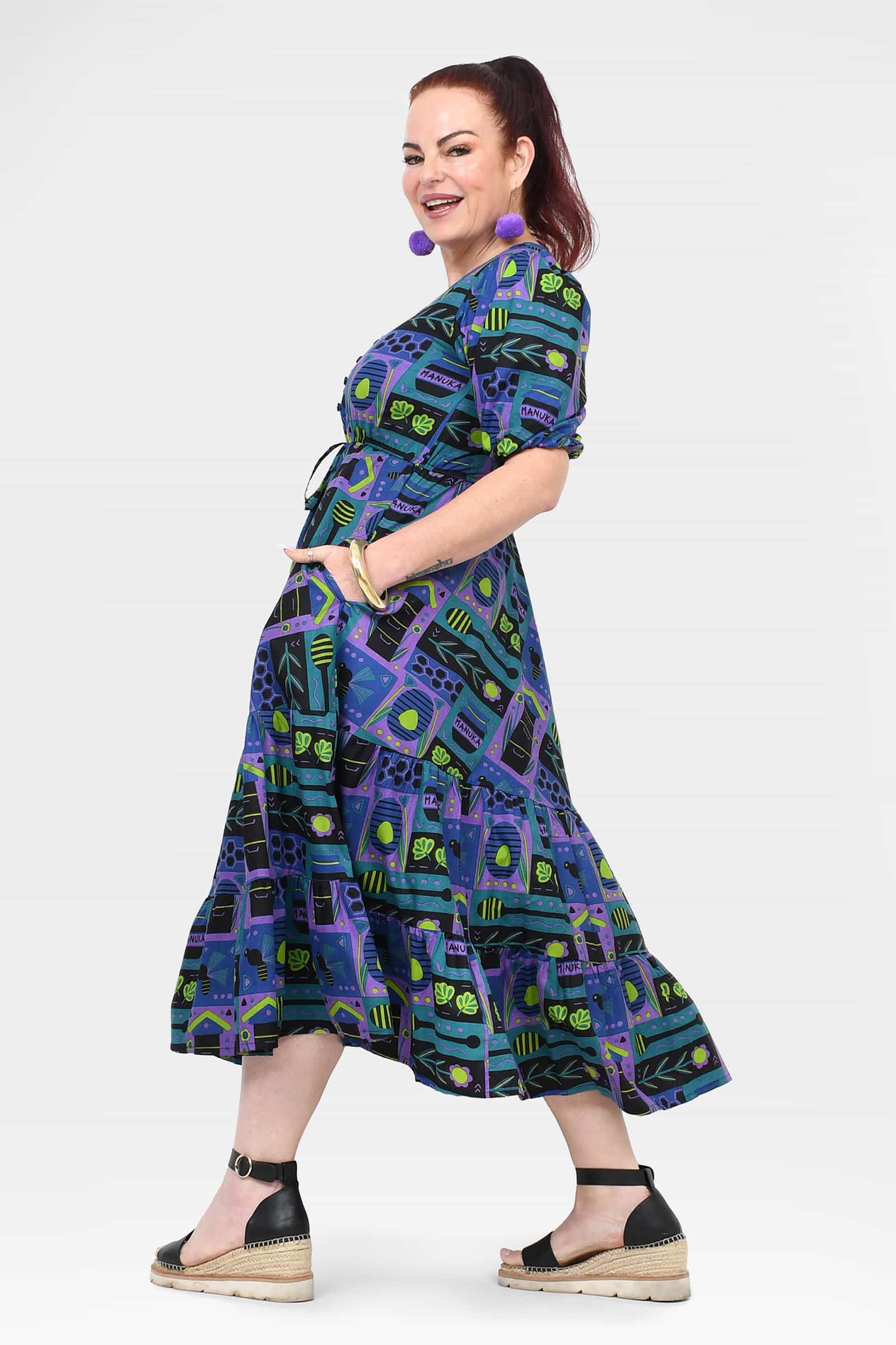 Ava midi dress on model, side/back view with gathered waist and tiered midi skirt