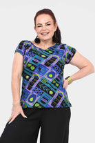 Printed teal crew-neck tee with colorful abstract insect-and-gear pattern, short sleeves