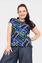 Printed teal crew-neck tee with colorful abstract insect-and-gear pattern, short sleeves