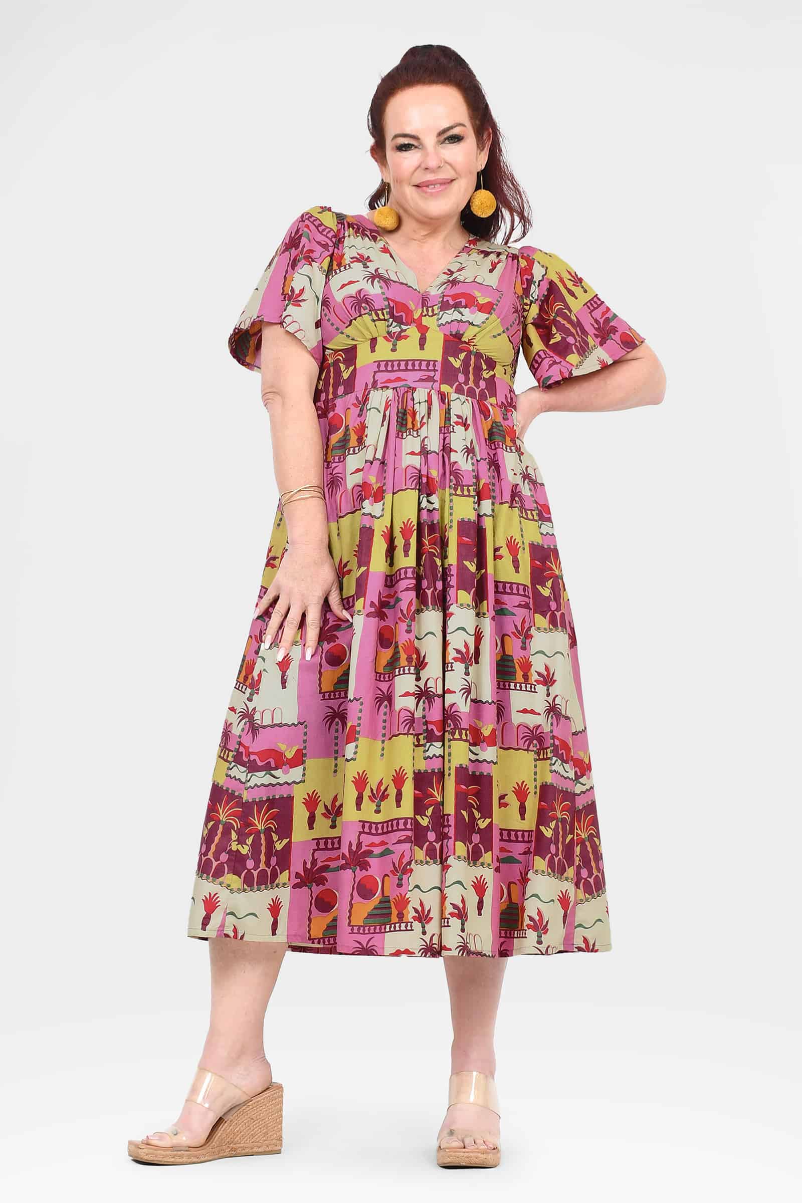Pink midi dress with V-neck, short sleeves, and colorful patchwork print