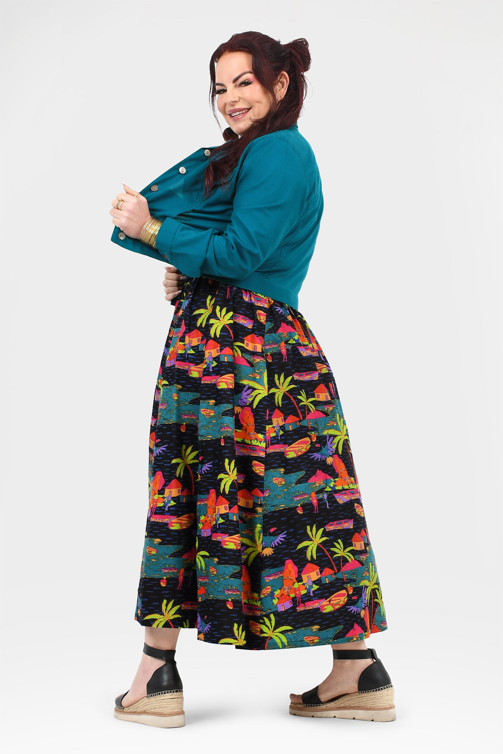 Tropical print long skirt with flared hem in multicolor peeking under a teal jacket